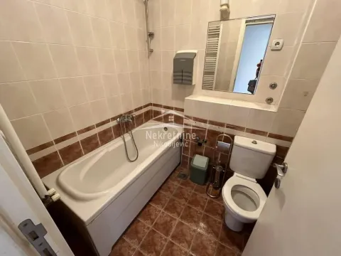 Bathroom equipped with a bathtub, toilet, and sink with a mirror. - image 17