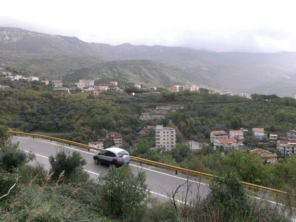 Pogled na brda i naselje u daljini sa puta.