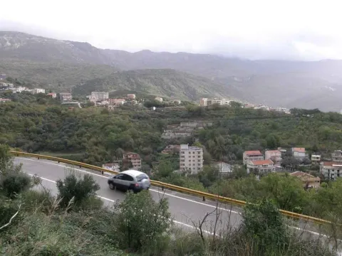 Pogled na brda i naselje u daljini sa puta. - image 4