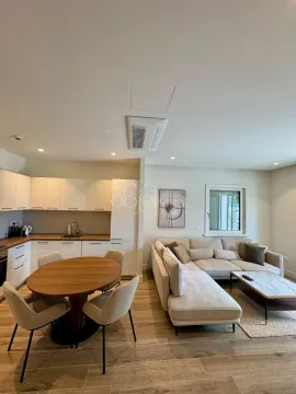Open-plan living room with dining area and kitchen. - image 7