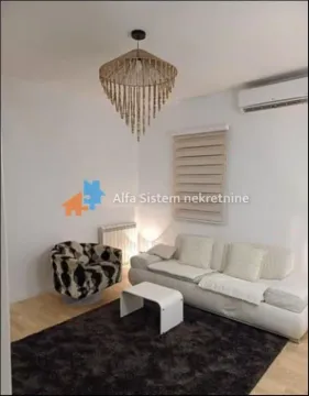 Dnevna soba sa garniturom, foteljom i dekorativnim lusterom. - image 3