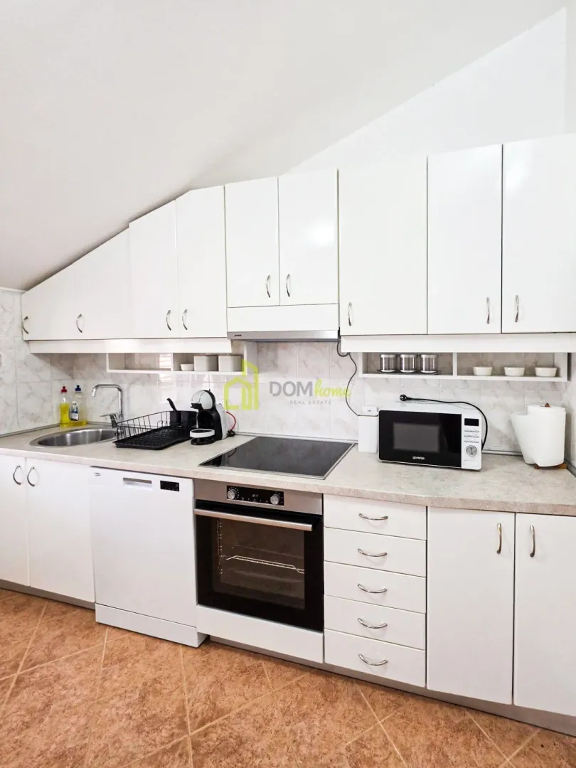 White kitchen with built-in appliances and a sink.