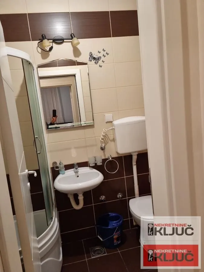 Manje kupatilo sa tuš kabinom, umivaonikom i toaletom.