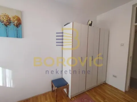 Spavaća soba sa belim garderoberom i drvenim podom. - image 6