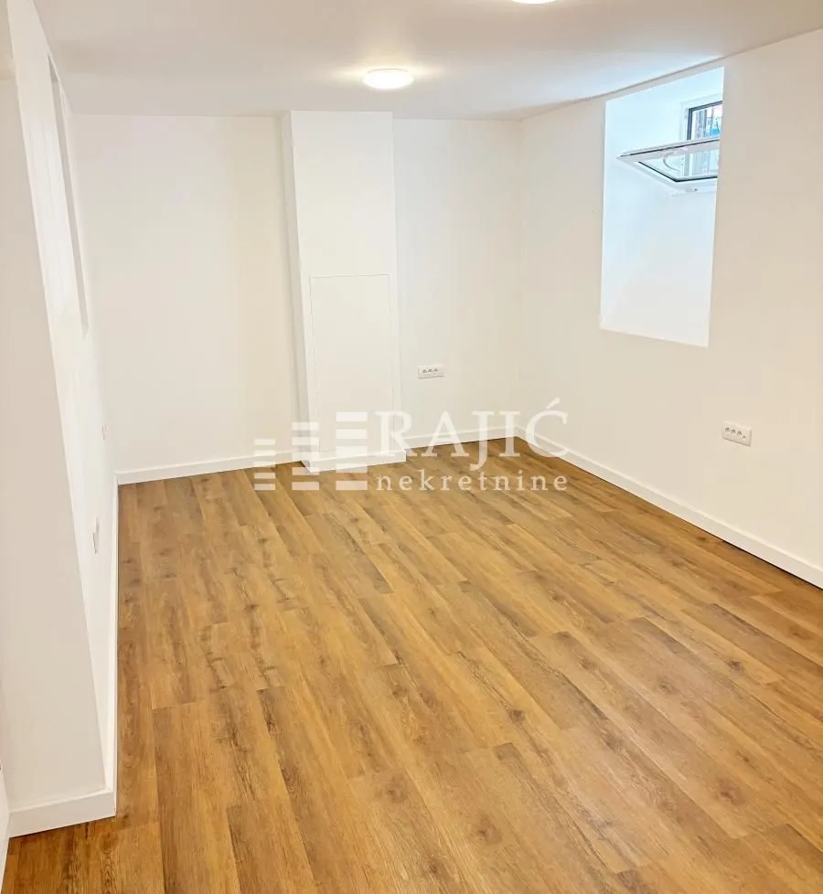 Empty bright room with wooden flooring.