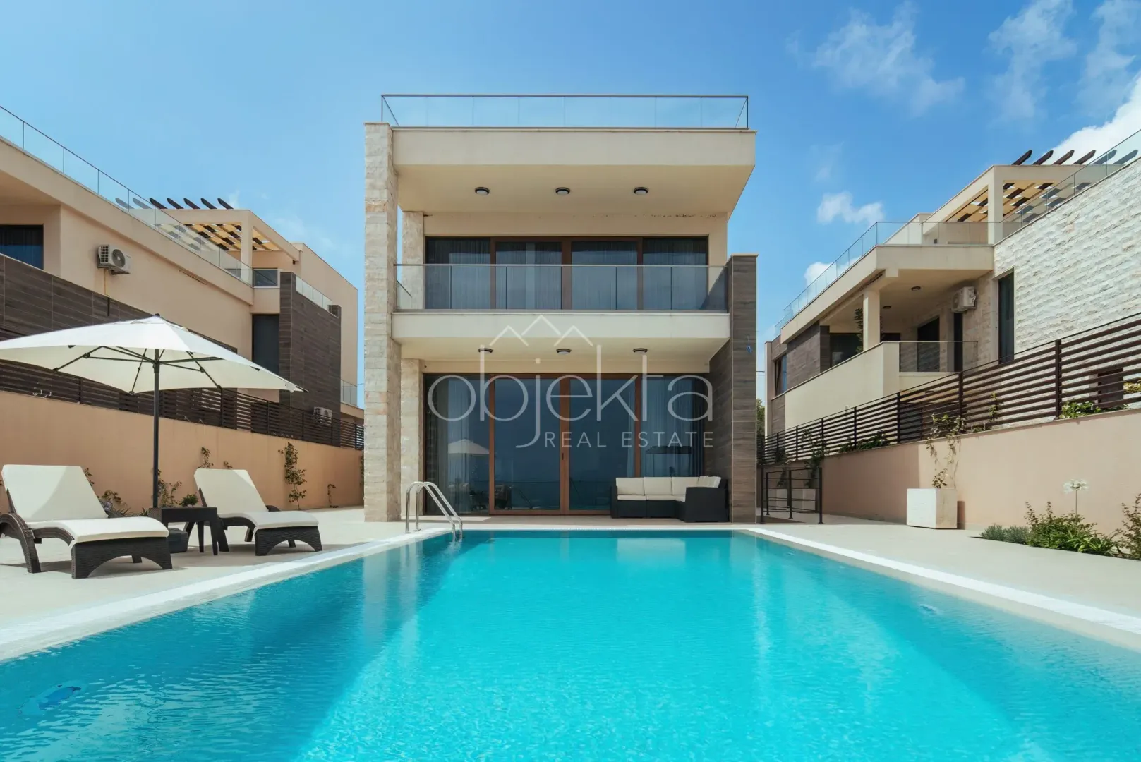 Modern villa with a swimming pool and landscaped yard.