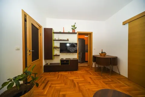 Living room with wooden flooring, a TV, and a dining table. - image 29