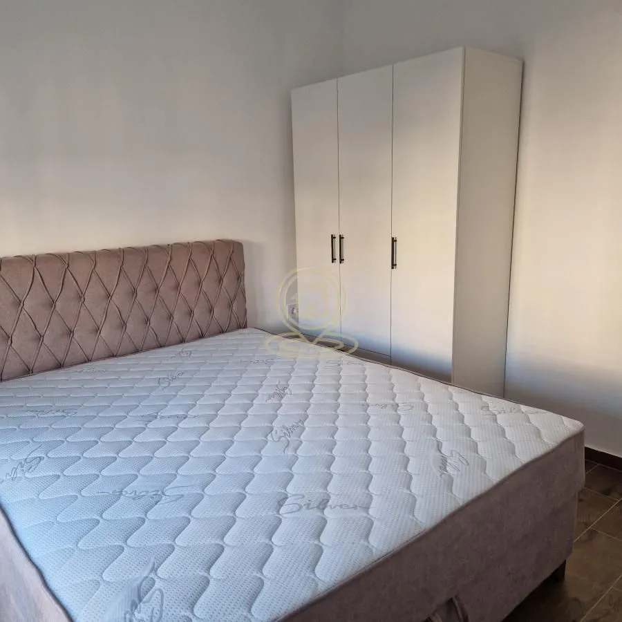 Spavaća soba sa bračnim krevetom i belim garderoberom.