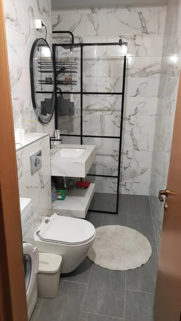 Moderno opremljeno kupatilo sa tuš kabinom, umivaonikom i WC šoljom.