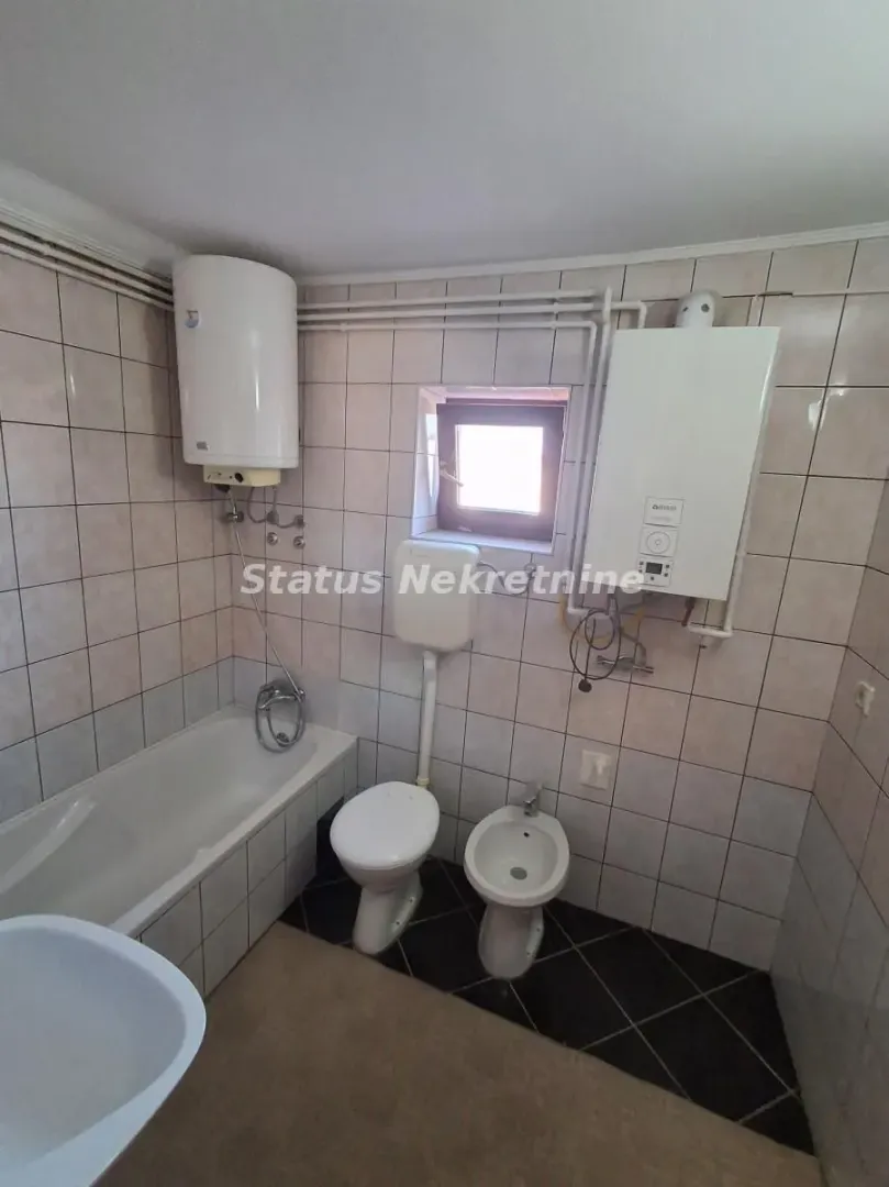 Bathroom equipped with a bathtub, sanitary ware, and a water heater.