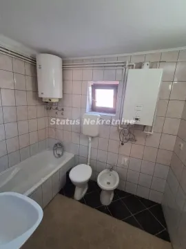 Bathroom equipped with a bathtub, sanitary ware, and a water heater. - image 8