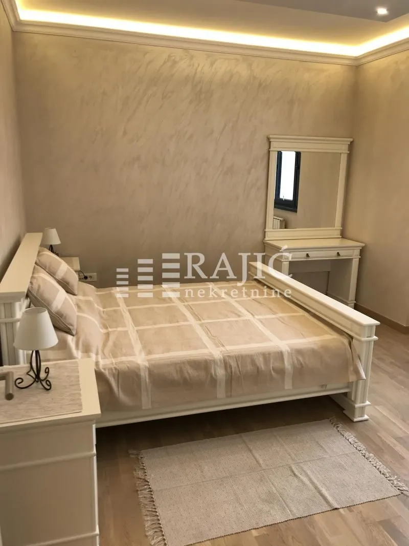 Furnished bedroom with a double bed and a vanity table.