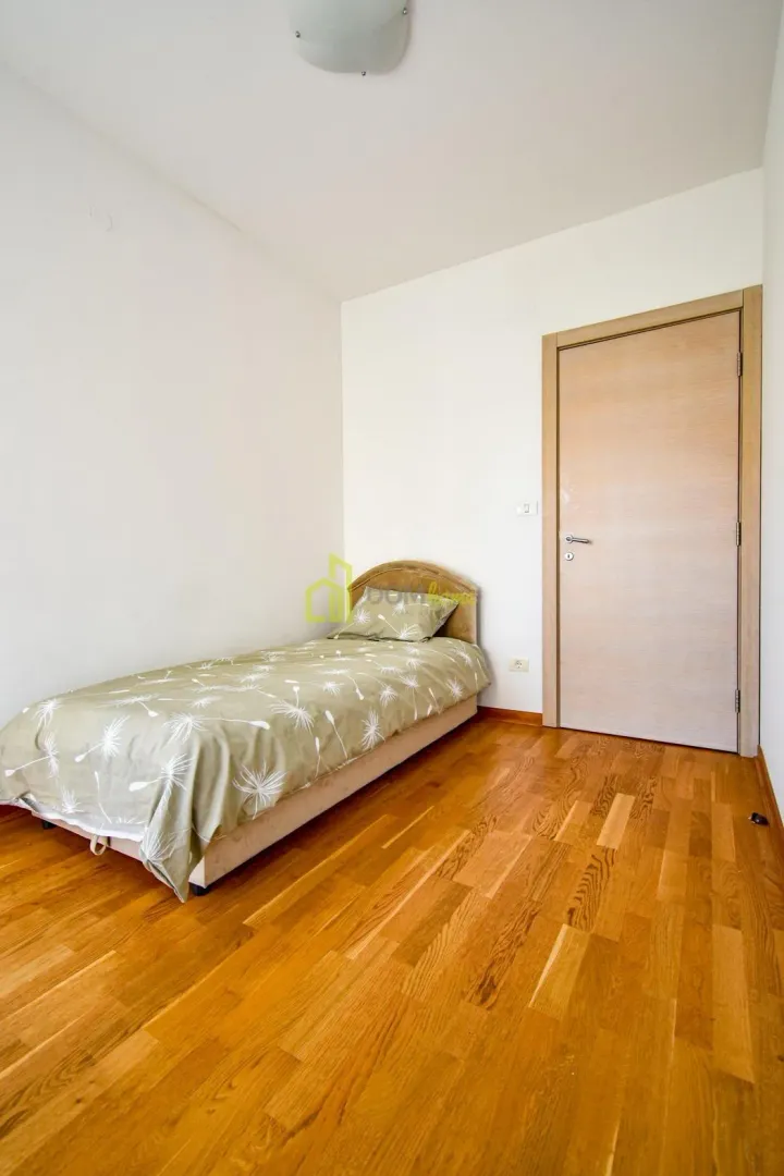 Small bedroom with a bed and wooden floor.
