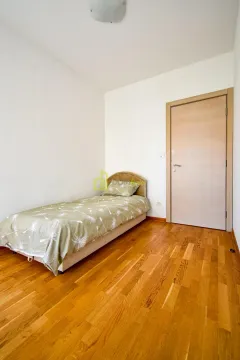 Small bedroom with a bed and wooden floor. - image 21