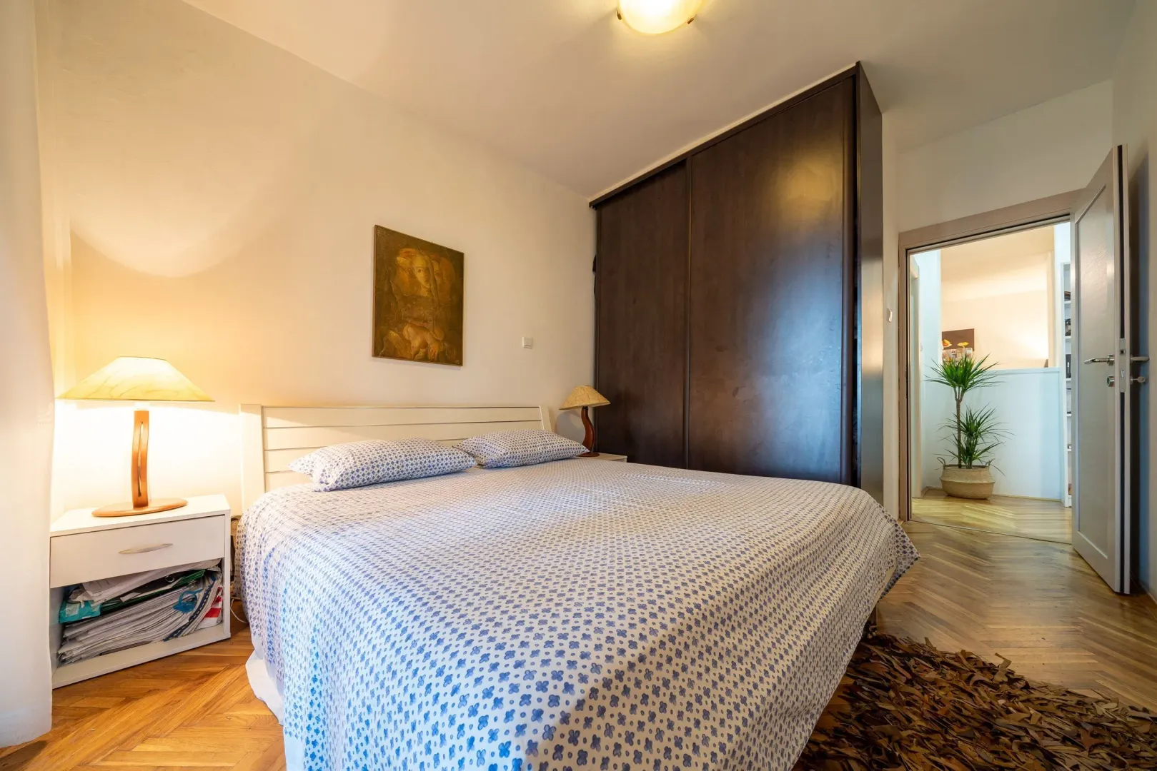 Furnished bedroom with a double bed, wardrobe, and nightstand.