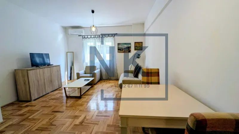 Living room with sofa set, TV cabinet, and dining table.