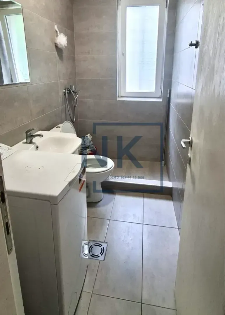 Kupatilo obloženo keramičkim pločicama sa umivaonikom, wc šoljom i veš mašinom.