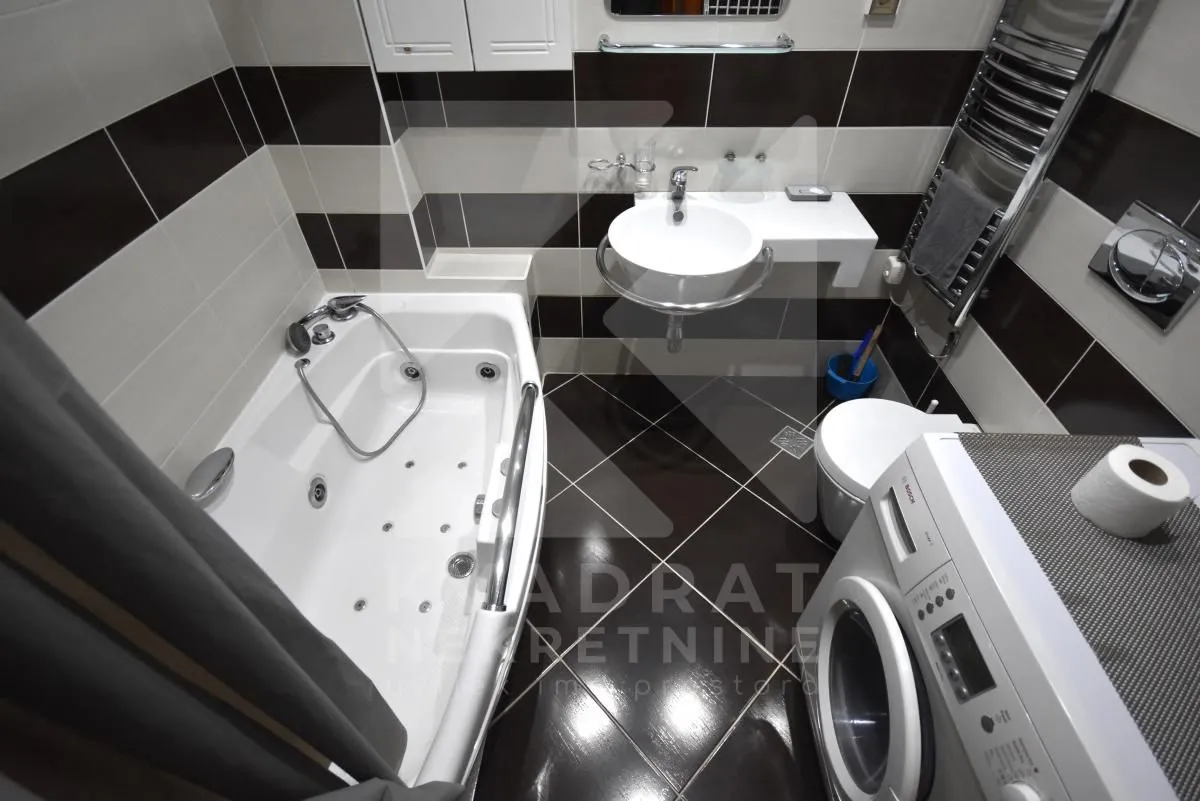 Bathroom equipped with a bathtub, washbasin, toilet, and washing machine.