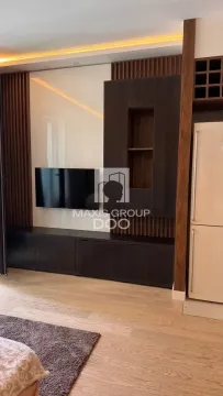 Living room with modern wooden elements, TV, and refrigerator. - image 15
