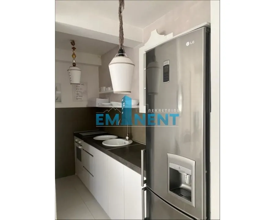 Small kitchen with white units and a built-in refrigerator.