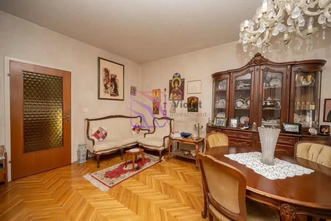 Dnevna soba sa garniturom za sjedenje, trpezarijskim stolom i tradicionalnim namještajem.
