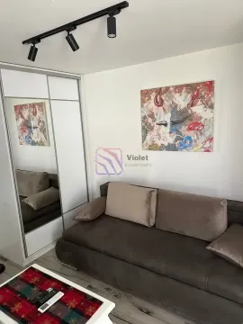 Living room with a brown sofa, white wardrobe with a mirror, and a painting on the wall. - image 3