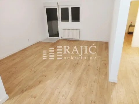 Empty room with wooden flooring and white walls. - image 2