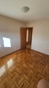 Prazna soba sa parketom i otvorenim drvenim vratima. - image 10