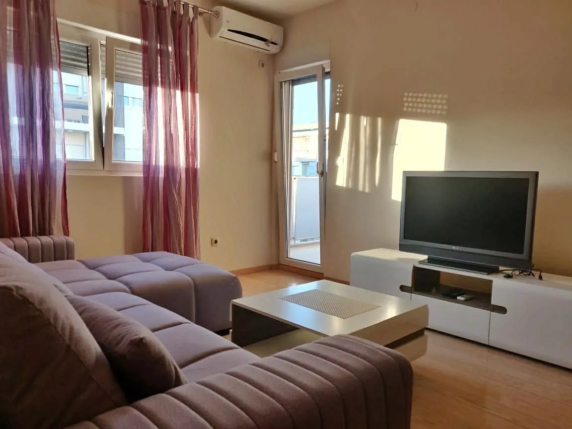 Bright living room with a sectional sofa and a TV.