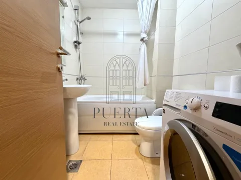 Smaller bathroom with a bathtub, washbasin, toilet, and washing machine. - image 7