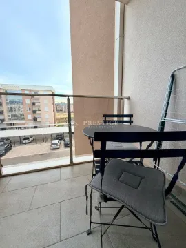Manji namješten balkon sa stolom, stolicama i pogledom na parking. - image 14