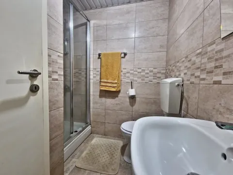 Bathroom with a shower cabin, washbasin, and toilet. - image 10