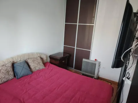 Spavaća soba sa bračnim krevetom, plakarom i televizorom na zidu. - image 5