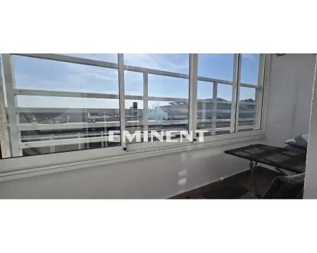 Enclosed balcony with a small table and chairs. - image 19