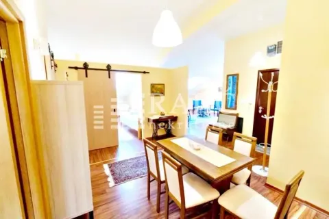 Dining area with a wooden table and chairs as part of the living room. - image 8