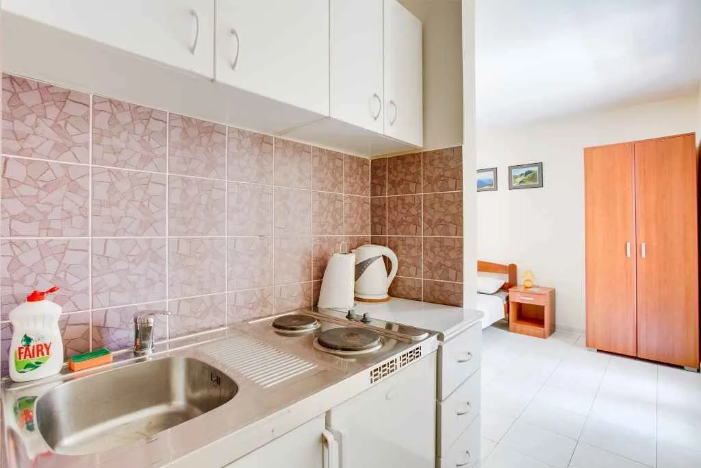 Mala kuhinja pored spavaćeg dijela u apartmanu.