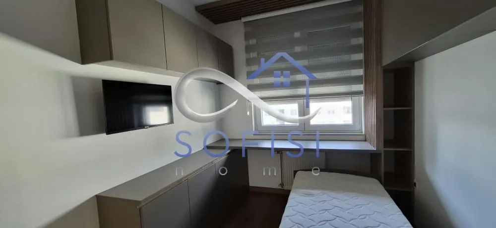 Small bedroom with a bed, built-in units, and a wall-mounted TV.