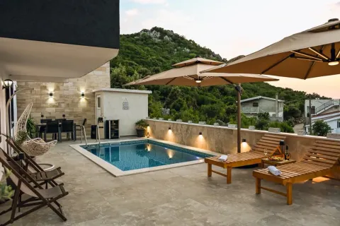 Terrace with a swimming pool, sun loungers, and umbrellas in front of the house. - image 2