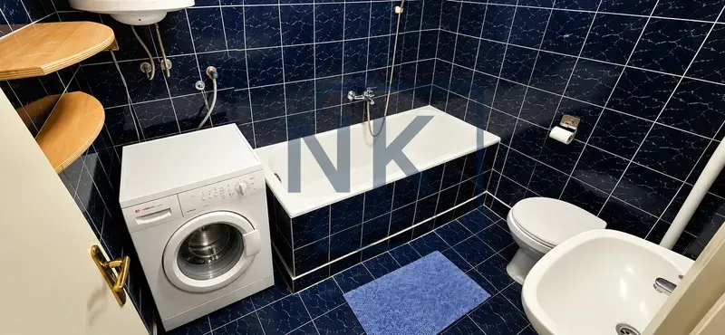Kupatilo opremljeno kadom, umivaonikom, WC šoljom i veš mašinom.