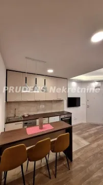 Small kitchen with beige cabinets and a dining table with chairs. - image 13