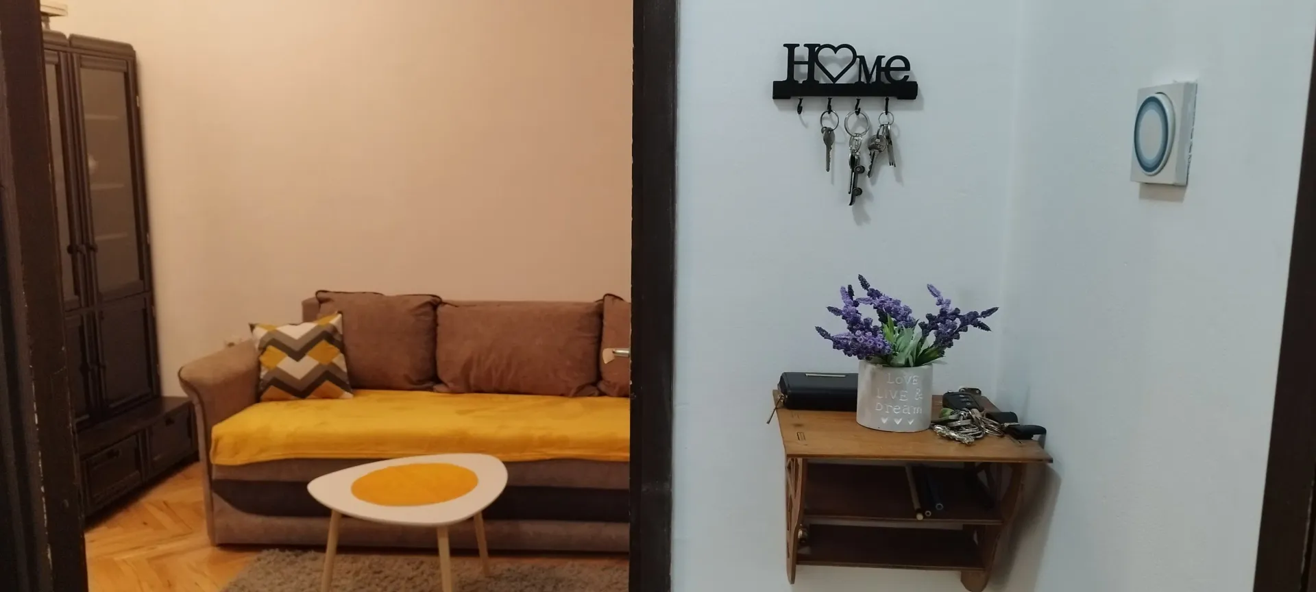 Pogled iz hodnika na dnevnu sobu sa garniturom i stočićem.