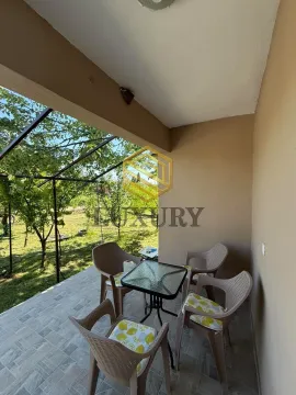 Covered terrace with seating furniture and a view of the yard. - image 3