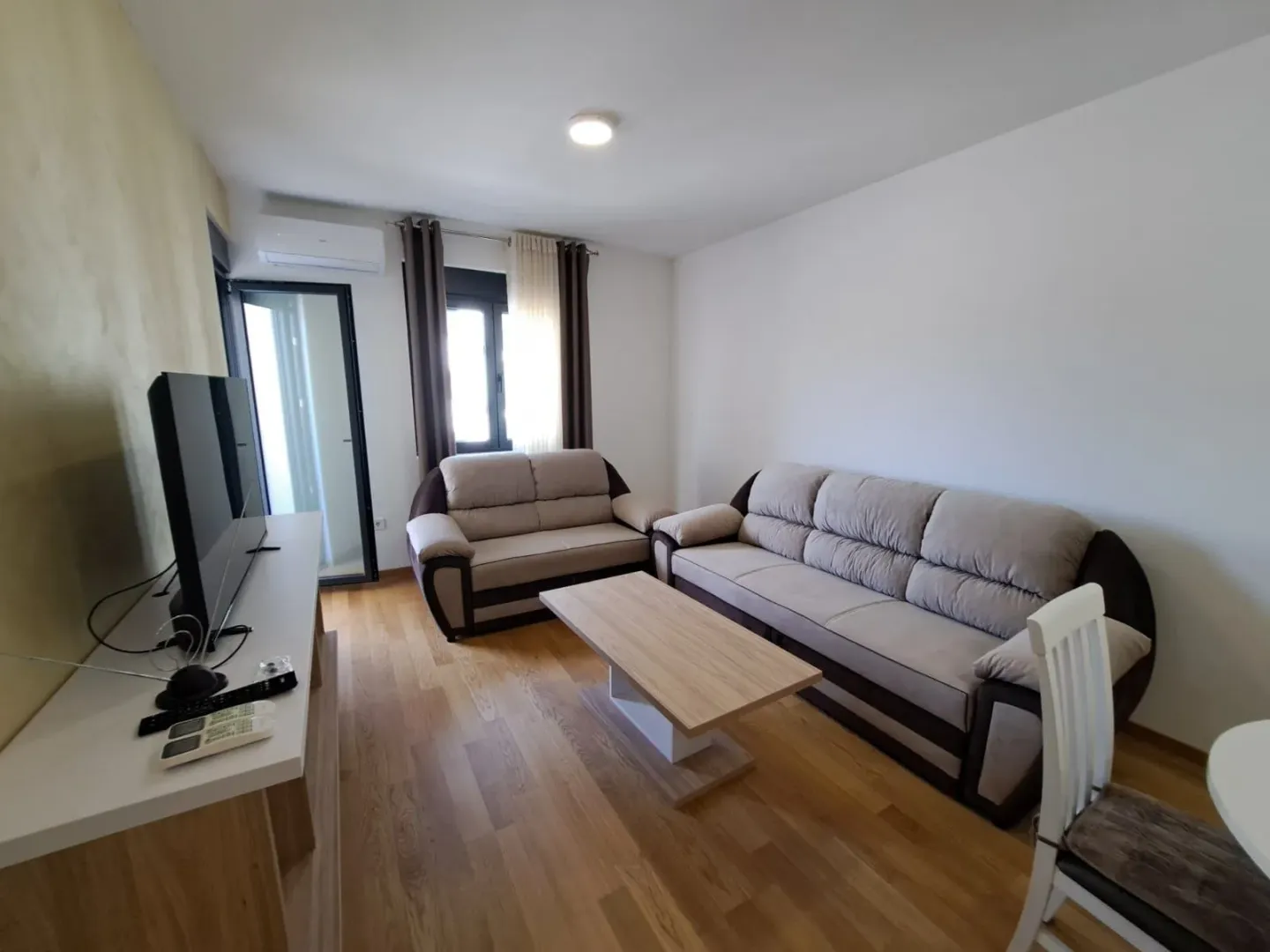 Living room with sofa set, coffee table and television.