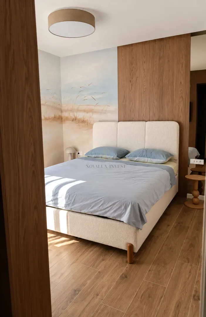 Modern bedroom with a double bed and wooden wall paneling.