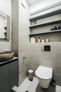 Modern bathroom with a stone basin and a wall-hung toilet. - image 13