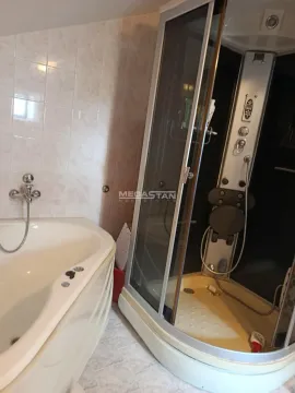 Bathroom equipped with a corner bathtub and a shower cabin. - image 15