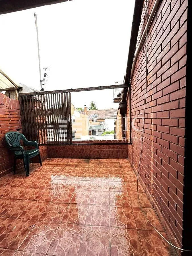 Covered terrace with ceramic tiles and brick walls.