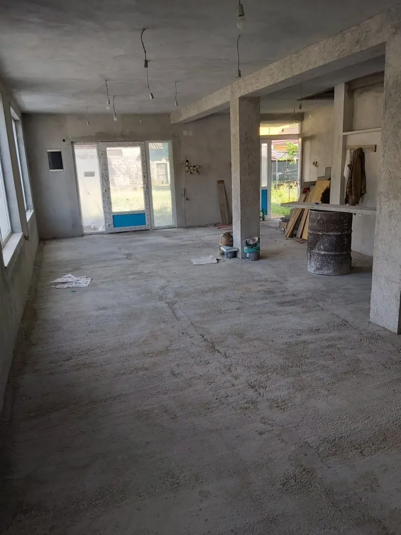 Spacious unfinished room in the rough construction phase with concrete floors.