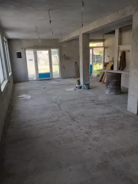 Spacious unfinished room in the rough construction phase with concrete floors. - image 8