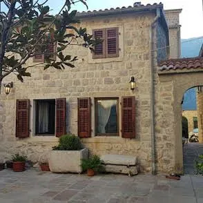 Fasada tradicionalne kamene kuće sa drvenim škurama i popločanim dvorištem. - image 19